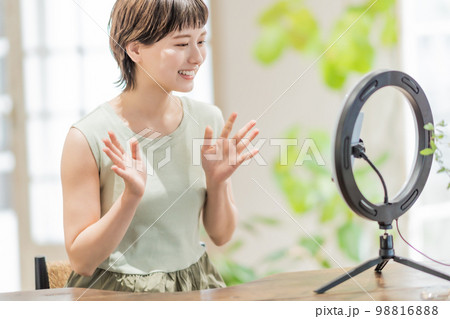 動画配信でフォロワーに話しかける若い女性 98816888