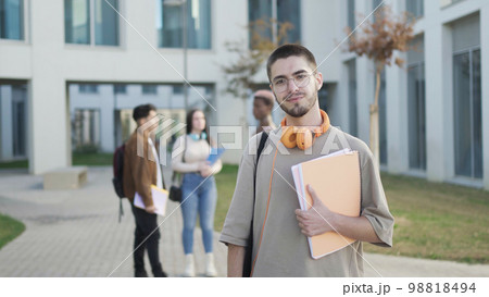 Positive man with papers on street with notebook Positive man with papers on street with notebook 98818494