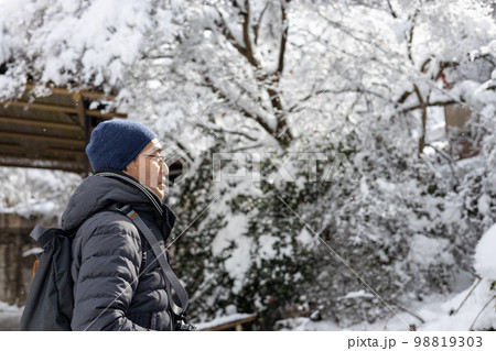 雪の積もった日に旅行している一人の中高年男性 雪の積もった日に旅行している一人の中高年男性 98819303