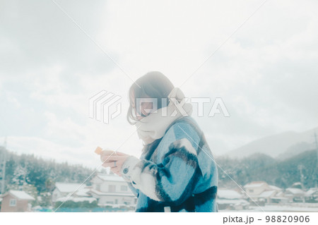 雪の中若い女性が暖かい飲み物を持っている写真 98820906