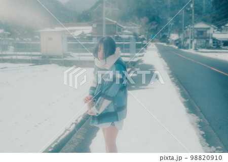 雪の中若い女性が暖かい飲み物を持っている写真 98820910
