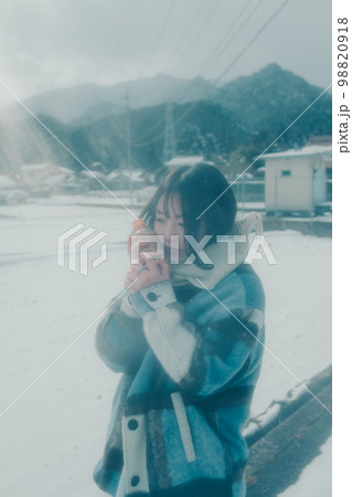 雪の中若い女性が暖かい飲み物を持っている写真 雪の中若い女性が暖かい飲み物を持っている写真 98820918