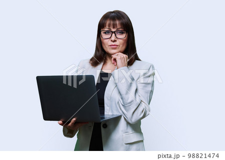 Mature business woman with laptop, on light studio background 98821474