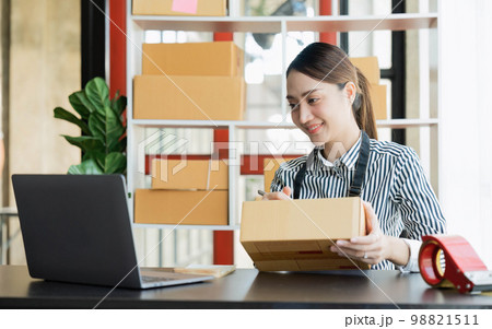Asian girl working with boxes at home office small business owner start up Entrepreneur, small business, SME or self-employed online and delivery concept Asian girl working with boxes at home office small business owner start up Entrepreneur, small business, SME or self-employed online and delivery concept 98821511