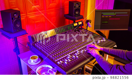 male professional sound engineer, music producer hands working on audio mixing console in home studio 98821556