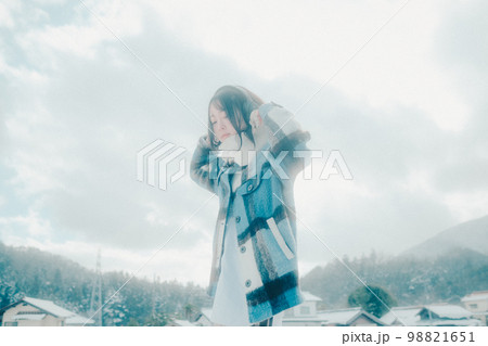 雪の中若い女性が音楽を聴いてる写真 雪の中若い女性が音楽を聴いてる写真 98821651