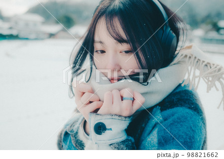 雪の中若い女性が音楽を聴いてる写真 雪の中若い女性が音楽を聴いてる写真 98821662