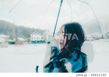雪の中若い女性が傘をさしている写真 雪の中若い女性が傘をさしている写真 98822140