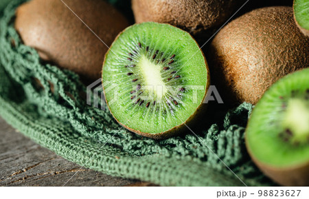 Kiwi fruits in a mesh bag, close -up. 98823627