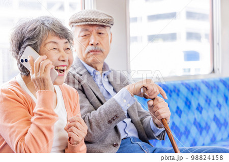 電車内　スマホで会話をするシニア女性 98824158
