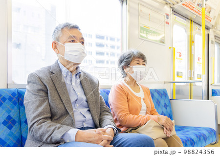 電車でマスクをつけるシニア男女 電車でマスクをつけるシニア男女 98824356
