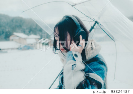 雪の中若い女性が音楽を聴いてる写真 雪の中若い女性が音楽を聴いてる写真 98824487