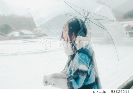 雪の中若い女性が音楽を聴いてる写真 雪の中若い女性が音楽を聴いてる写真 98824512