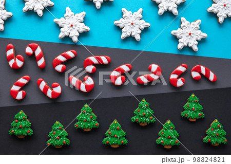 Christmas gingerbread covered with icing on a colored background, flat lay. Christmas gingerbread covered with icing on a colored background, flat lay. 98824821
