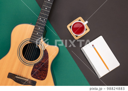 Flat lay, acoustic guitar and notebook on color background. Flat lay, acoustic guitar and notebook on color background. 98824883