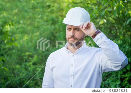 Man constructor wearing hardhat outdoors natural background, copy space Man constructor wearing hardhat outdoors natural background, copy space 98825381