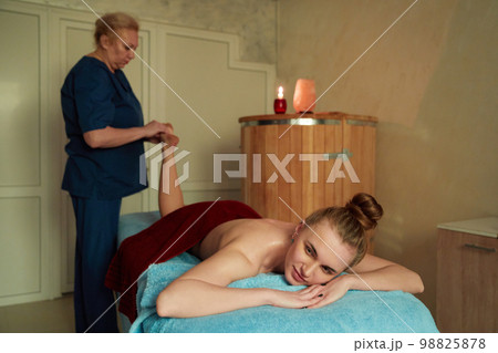 Young woman receiving massage in spa salon 98825878