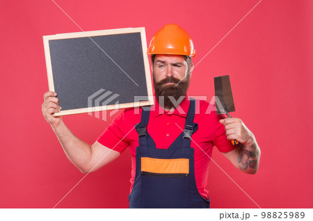 Renovation company services. Professional plasterer. Skillful plasterer. Bearded man worker with plastering tool. Plasterer hipster builder in hard hat hold blackboard copy space. Best offer here Renovation company services. Professional plasterer. Skillful plasterer. Bearded man worker with plastering tool. Plasterer hipster builder in hard hat hold blackboard copy space. Best offer here 98825989