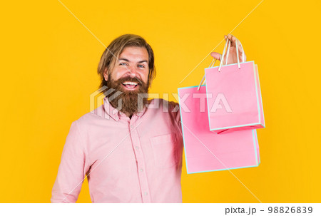 mature man with beard and trendy hairstyle hold gift package, shopaholic mature man with beard and trendy hairstyle hold gift package, shopaholic 98826839