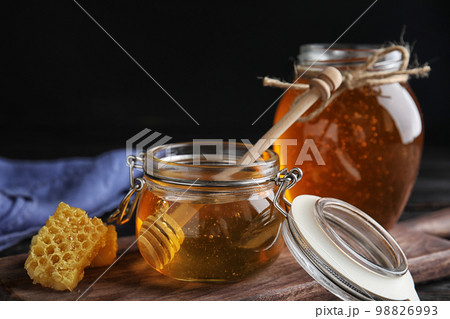 Jar of sweet honey on wooden board Jar of sweet honey on wooden board 98826993