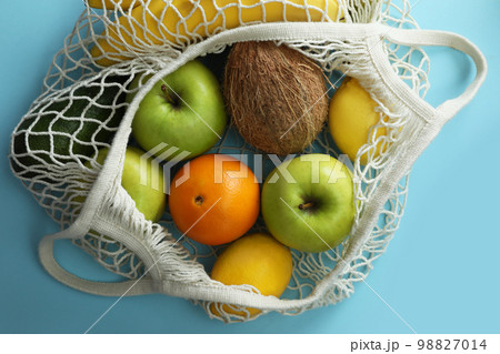 Net bag with fruits on light blue background, top view Net bag with fruits on light blue background, top view 98827014