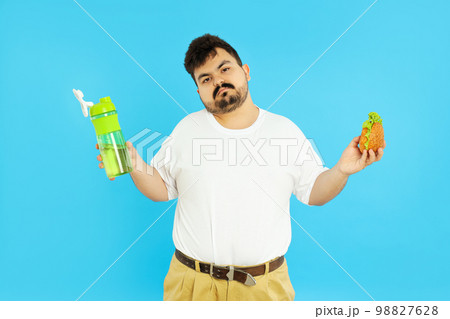 Concept of weight problems, young fat man on blue background 98827628