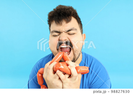 Concept of weight problems, young fat man on blue background Concept of weight problems, young fat man on blue background 98827630