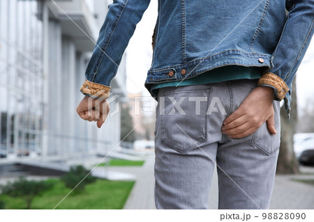 Man suffering from hemorrhoid pain outdoors, back view 98828090