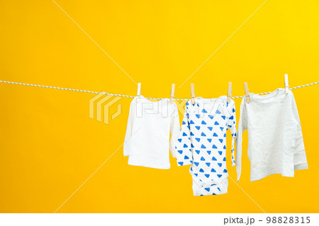 Laundry hanging and drying on twine on yellow background Laundry hanging and drying on twine on yellow background 98828315