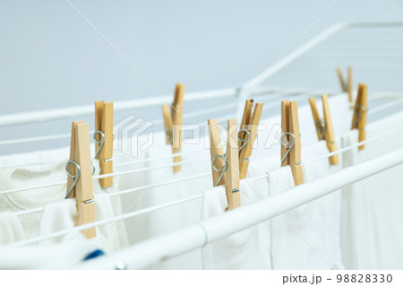 Drying rack with socks and clothes against light background Drying rack with socks and clothes against light background 98828330