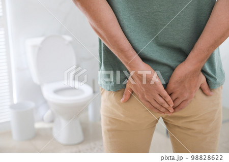 Man suffering from hemorrhoid in rest room, closeup 98828622