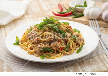 Stir fried Spaghetti with Canned tuna fish and crispy basil leaves in white plate,Spicy pasta Pad Kra Pao.Thai fusion food Stir fried Spaghetti with Canned tuna fish and crispy basil leaves in white plate,Spicy pasta Pad Kra Pao.Thai fusion food 98830328