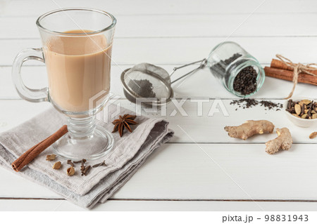 A glass of hot Indian masala tea brewed with aromatic spices and milk A glass of hot Indian masala tea brewed with aromatic spices and milk 98831943