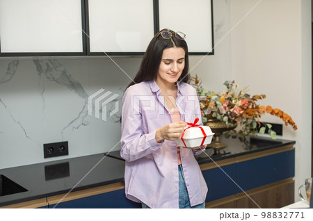 Cute girl opens a white gift box, unties the ribbon 98832771