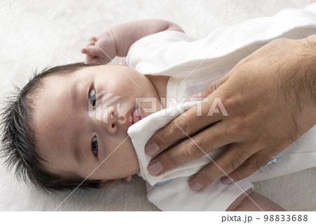 赤ちゃんの口を拭く男性の手（0歳2ヶ月・日本人・男の子） 98833688