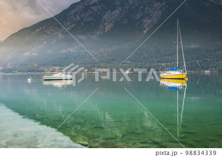 Sailboats on Achensee lake near Innsbruck at peaceful dawn, Tyrol alps, Austria Sailboats on Achensee lake near Innsbruck at peaceful dawn, Tyrol alps, Austria 98834339