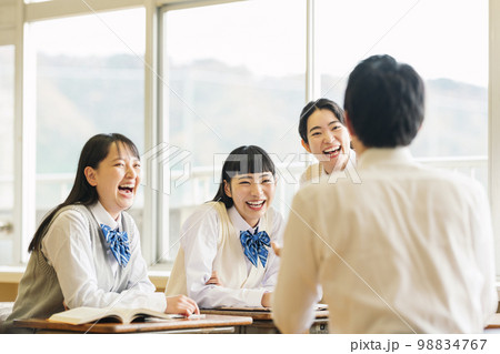 教室でクラスメイトと楽しく話す高校生 98834767