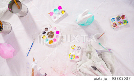 Flat lay. Little girl painting paper mache figurine at homeschooling art class. 98835087