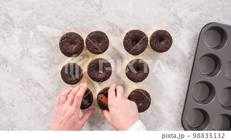 Flat lay. Step by step. Cooling freshly baked chocolate cupcakes to be decorated with buttercream frosting. 98835132