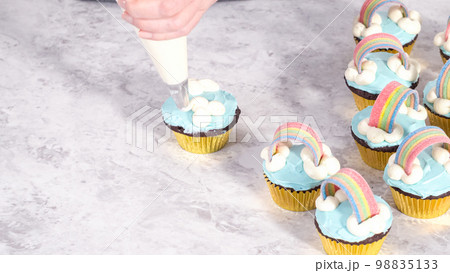 Step by step. Decorating chocolate cupcakes with buttercream frosting and rainbow candy. 98835133