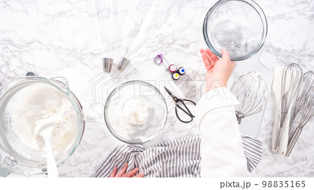 Step by step. Flat lay. Mixing food coloring into the meringue to bake unicorn meringue cookies. Step by step. Flat lay. Mixing food coloring into the meringue to bake unicorn meringue cookies. 98835165