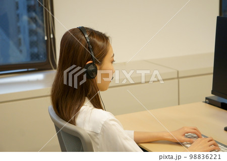 コールセンターで電話対応の業務を行う女性 98836221