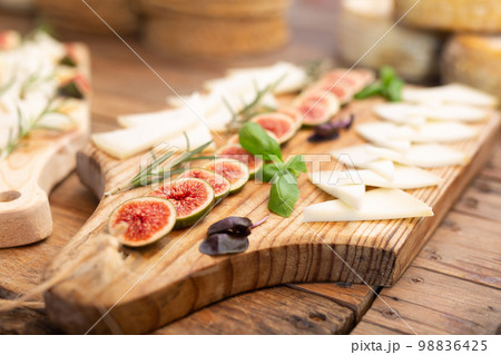 Sliced goat cheese with rosemary, basil and figs for tasting 98836425