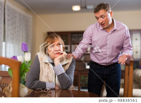 Elderly mother and adult son are offended at each other because of the misunderstanding in his home 98836561