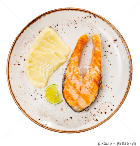 Fried salmon with mashed potato and lemon on white plate. Traditional spanish dish 98836738