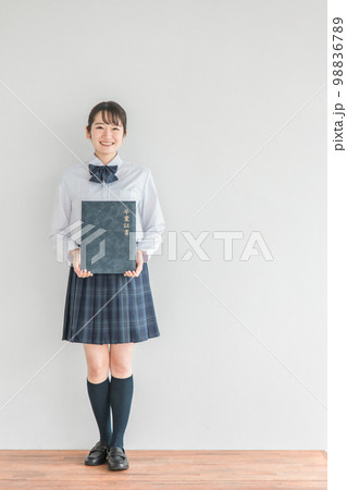 学校の教室で卒業証書・証書ファイルを持つ笑顔の高校生・中学生・女子高生（卒業式・制服・学生服） 98836789