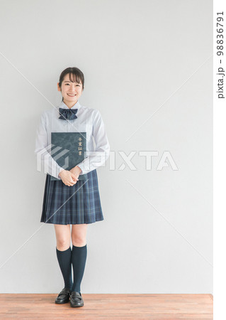 学校の教室で卒業証書・証書ファイルを持つ笑顔の高校生・中学生・女子高生（卒業式・制服・学生服） 98836791