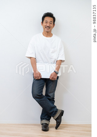 パソコンを持ったアラフィフ男性のシンプルなポートレート 98837135