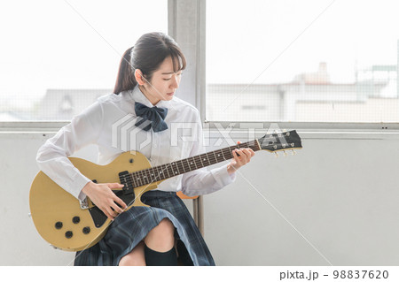 学校の教室で楽器・ギターの演奏をする軽音部・吹奏楽部の高校生・中学生・女子高生（制服・バンド） 98837620