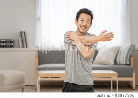 自宅のリビングで運動をする50代男性 自宅のリビングで運動をする50代男性 98837956